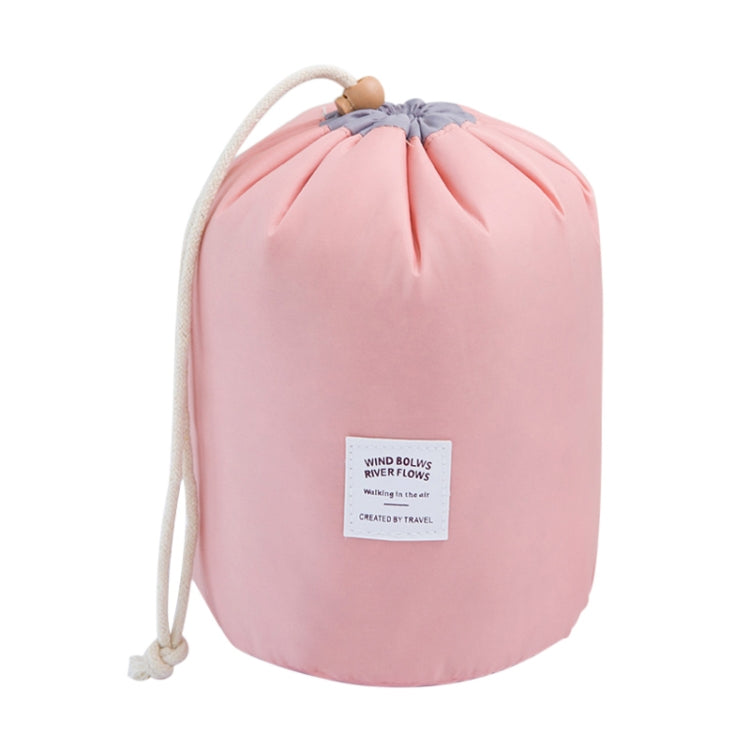 Pink round drawstring cosmetic bag with braided cord handle and front label