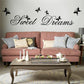 “Sweet Dreams” wall sticker with black butterflies above pink sofa pillows