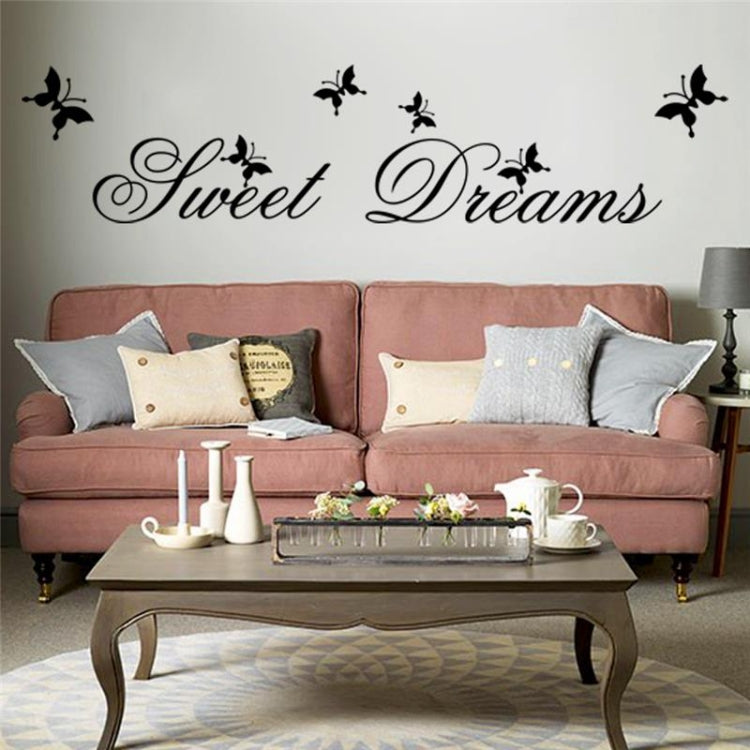 “Sweet Dreams” wall sticker with black butterflies above pink sofa pillows