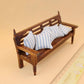 Mini wooden dollhouse bench with slatted back and blue-and-white striped pillows