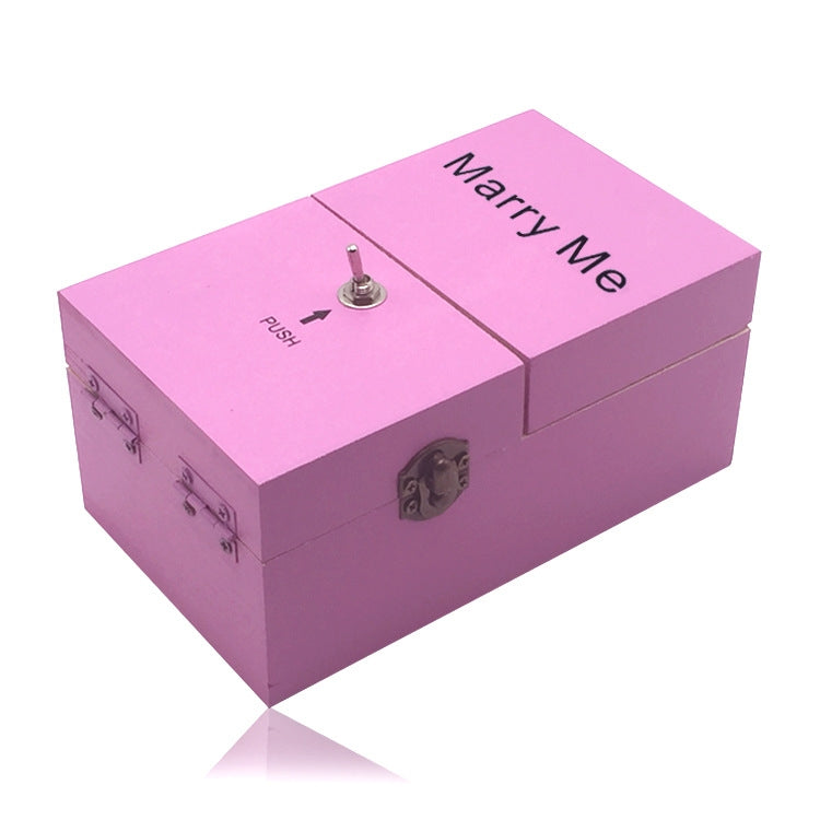 Pink wooden stress-relief gift box with “Marry Me” text and metal push knob