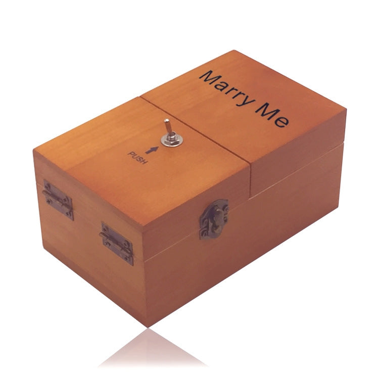 Orange wooden stress-relief gift box with “Marry Me” lid text and metal push knob