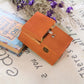 Orange wooden anti-stress gift box with metal knob, open lid showing hollow interior