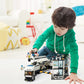 Child playing with police station building set, including police truck and officer minifigures.