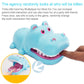 Cartoon hippo bite hand toy in light blue, with hand pressing the open-jaw mechanism