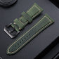 Olive green leather watch band with perforations, stitched border, and metal buckle.