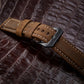 Tan leather watch band with stitched edge and metal buckle on strap.