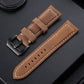 Light brown leather watch band with tan stitching, perforated holes, and metal buckle.