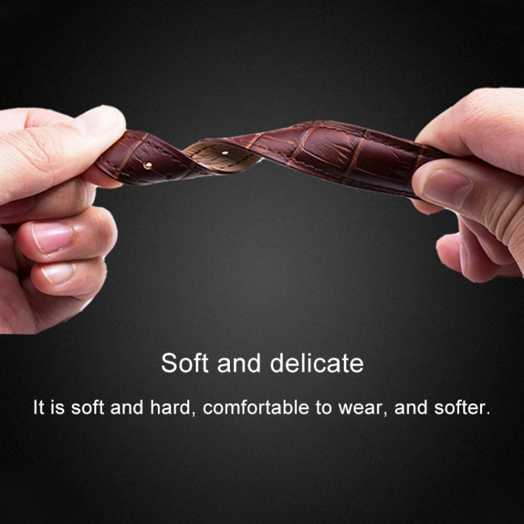 Dark leather watch band held in hands, with punched holes and stitched edges