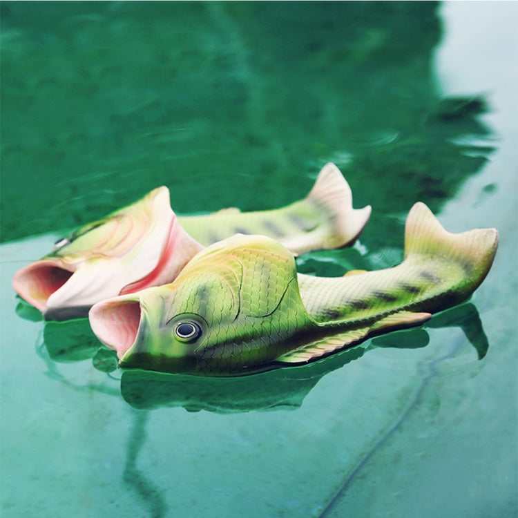 Fish-shaped green sandals floating on water, slip-on with open toe and scale texture.