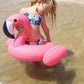 Pink flamingo inflatable pool float held by child in shallow water