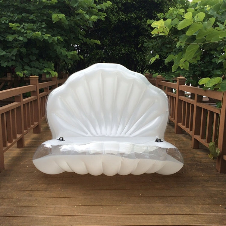 White scallop-shaped inflatable swimming floating mat set on a deck