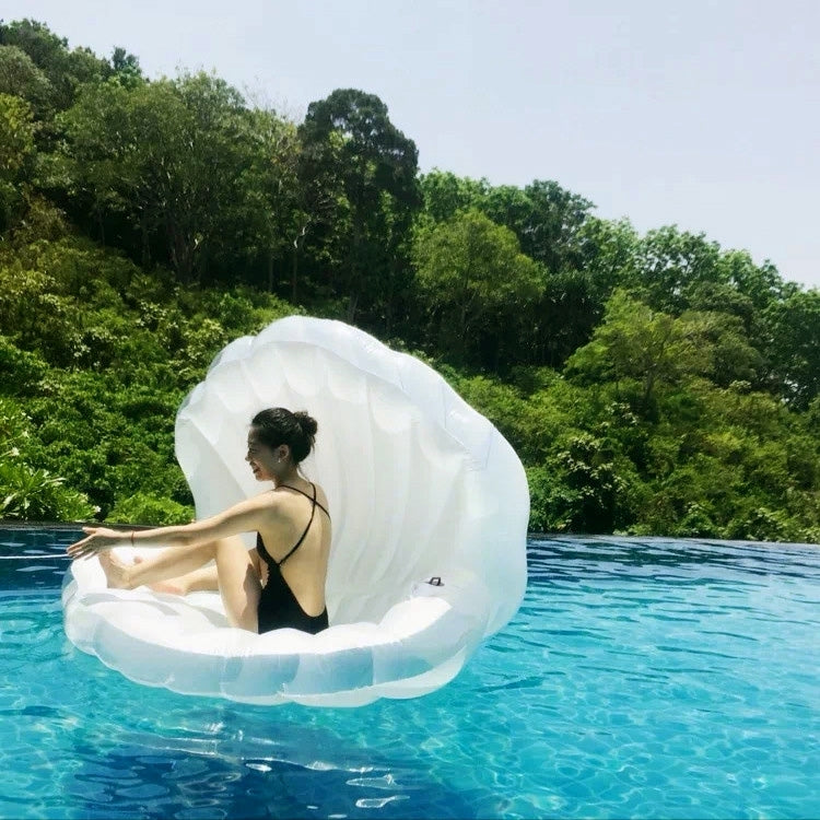 White scallop-shaped inflatable swimming floating mat floating on pool water