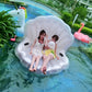 White scallop-shaped inflatable floating mat with two children in a pool