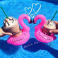 Inflatable pink flamingo drink holders with cup holders, held in hands