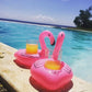 Inflatable pink flamingo drink holder holding two cups by the pool