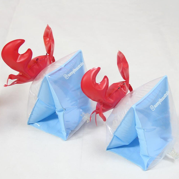 Set of red crab inflatable arm bands with light blue float sleeves, angled view