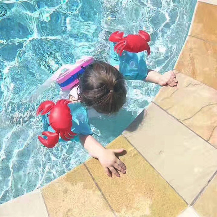 Child near the pool wearing red inflatable crab arm floats