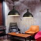 Black single-head pendant lights with dome shades hanging from metal chains