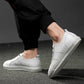 Men's white lace-up sneakers in profile view with low profile rubber sole
