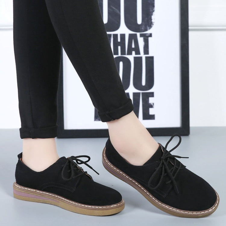 Black suede lace-up casual shoes with flat sole and tan trim, side view