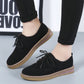 Black suede lace-up casual shoes with flat sole, tan edge trim, angled view