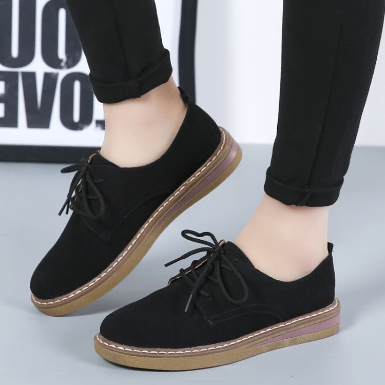 Black suede lace-up casual shoes with flat sole, tan edge trim, angled view