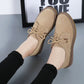 Tan suede lace-up casual shoes with flat sole and decorative lace eyelets.