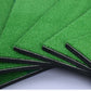 Side view of overlapping mat layers with black seams on green turf
