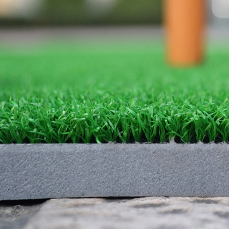 Edge close-up of green artificial turf on dark mat base