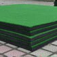 Corner view of green turf golf practice mat stacked with black foam layers
