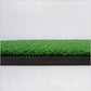 Green artificial grass golf practice mat with black edge trim and layered backing
