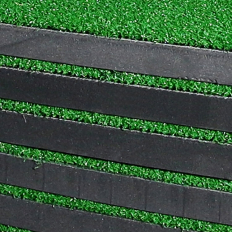 Close-up of black cushioning layers bordering a green turf golf practice mat