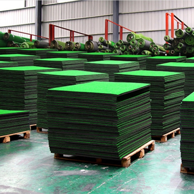 Green turf golf practice mats stacked on pallets with black backing layers