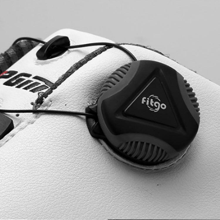 Rotary buckle close-up on waterproof golf sneakers, black device on white textured upper