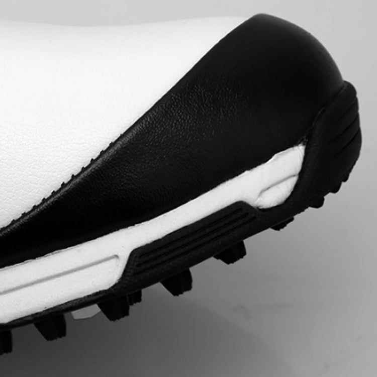 Black waterproof golf sneaker, close-up side with textured white midsole and grip lugs