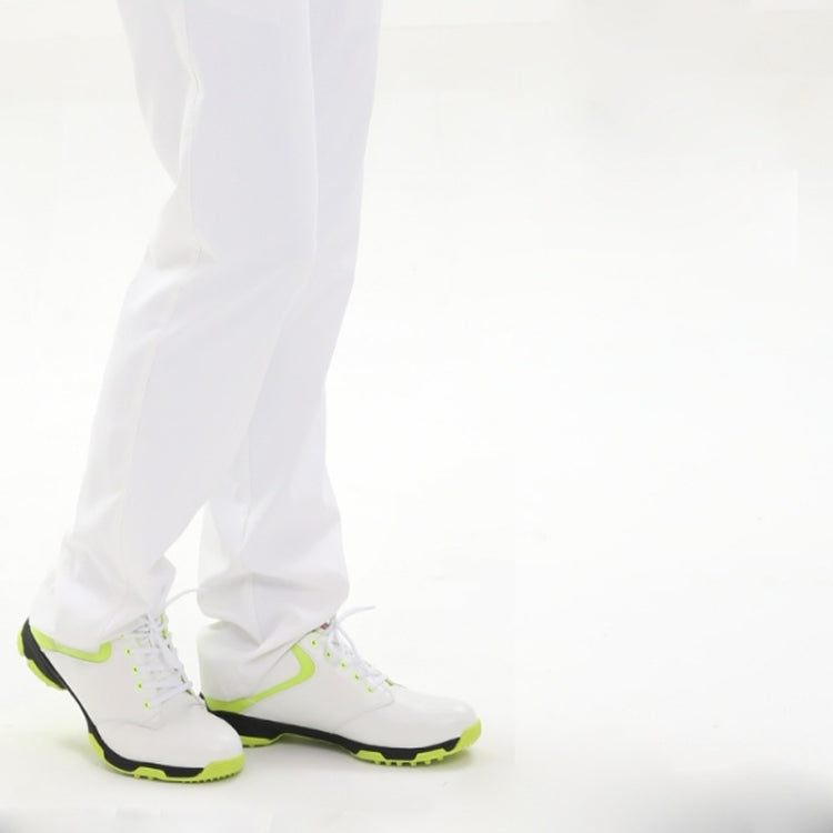 White golf sneakers with neon green trim worn with white pants