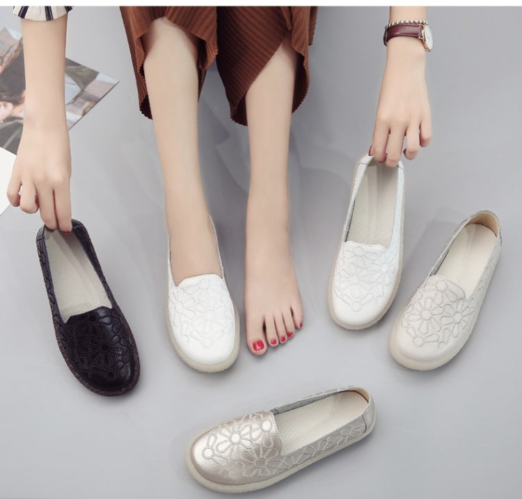 Women's floral-embossed slip-on flats in white and dark, shown with feet and spare pair.