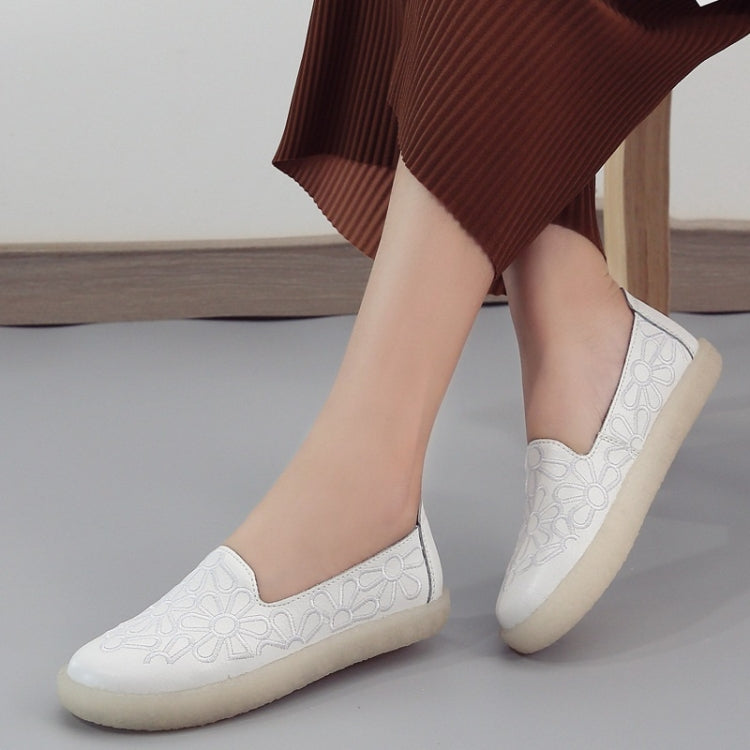 White embroidered slip-on casual shoes, side profile with floral stitching and rubber sole