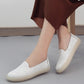White embroidered slip-on casual shoes featuring floral cutout-style stitching and low sole