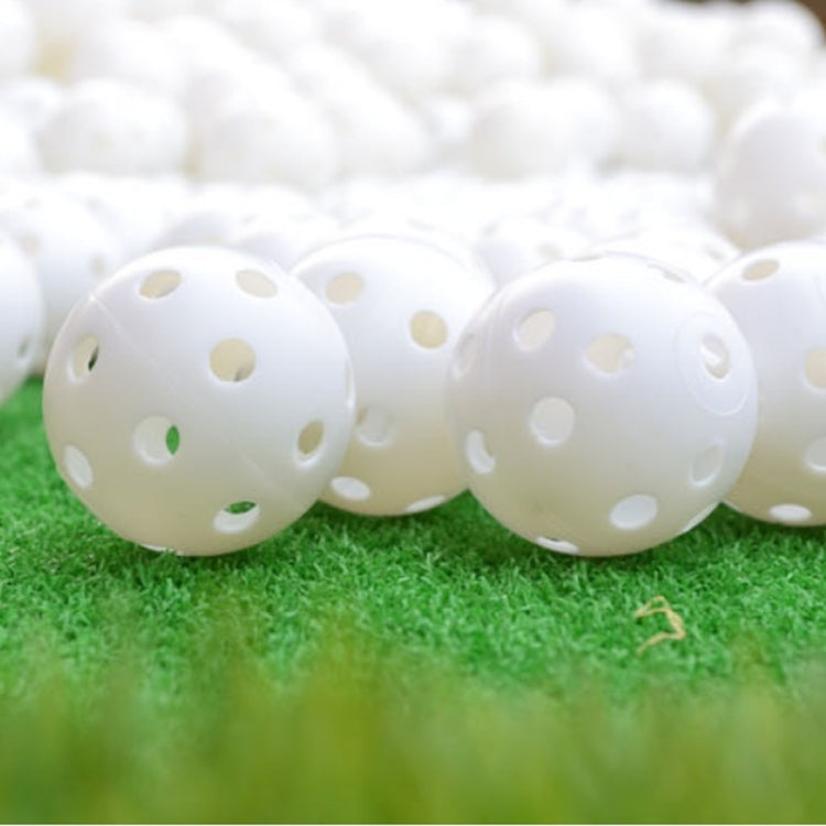 White hollow golf exercise balls, perforated plastic balls on turf