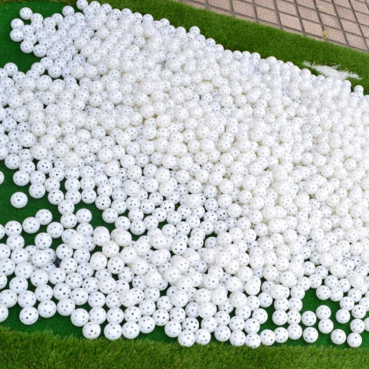 White hollow golf exercise ball set, large pile of perforated balls