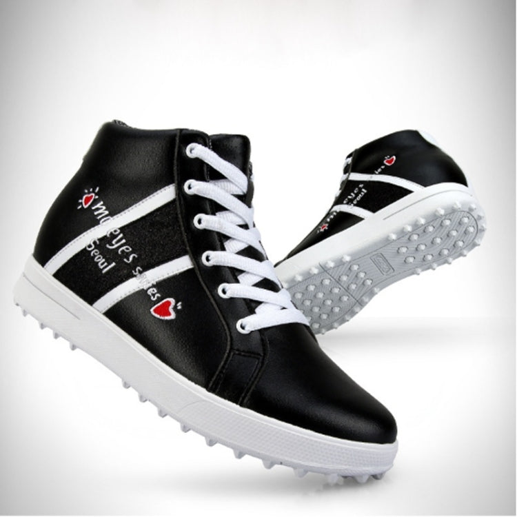 Black high-top golf sneakers with white stripe and heart-eye embroidery; studded sole
