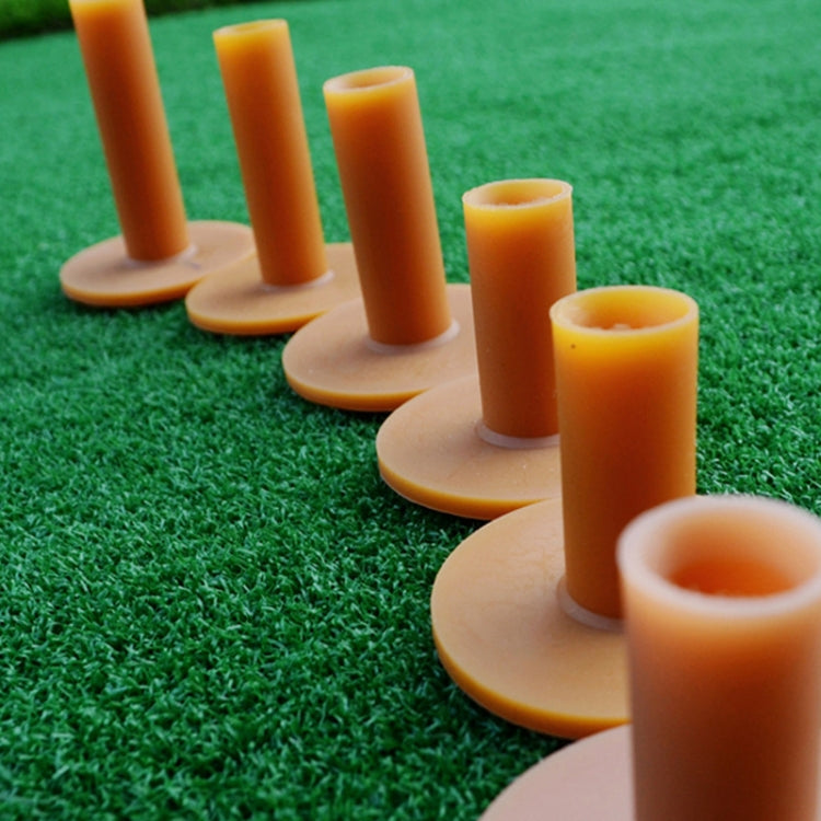 Row of amber rubber golf tendon tees on turf, each with round base and peg