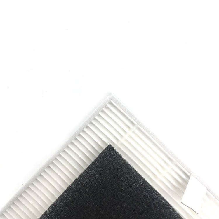 Vacuum cleaner filter corner showing white pleated grid beneath dark foam pad