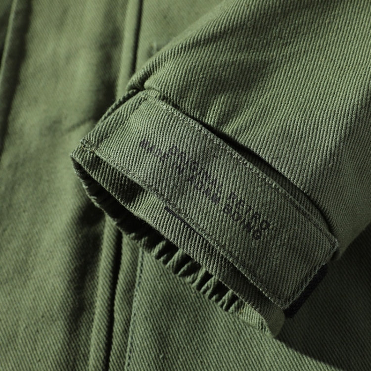Olive green jacket sleeve close-up with ribbed cuff and stitched seam