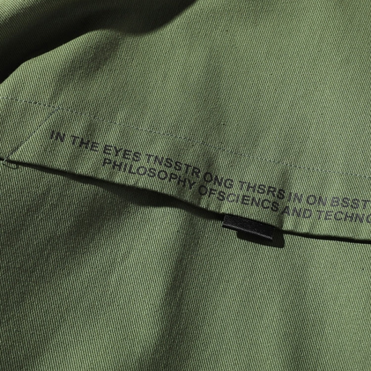 Olive green jacket zipper close-up with black pull tab