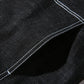 Black denim jacket seam detail with contrast stitching and textured fabric