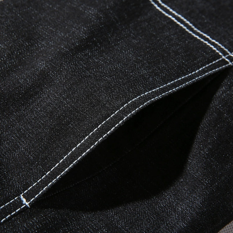 Black denim jacket seam detail with contrast stitching and textured fabric