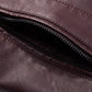 Close-up of maroon PU leather jacket pocket zipper with visible stitching
